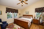 Nice King master bedroom with ceiling fan, mirror, dresser and end table.
